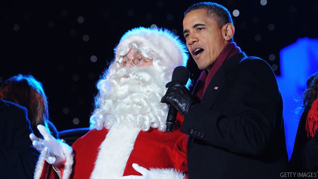 US President Barack Obama sings with Santa during the finale fo the annual lighting of the National Christmas tree December 1, 2011 at The Ellipse in Washington, DC. AFP PHOTO/Mandel NGAN (Photo credit should read MANDEL NGAN/AFP/Getty Images)